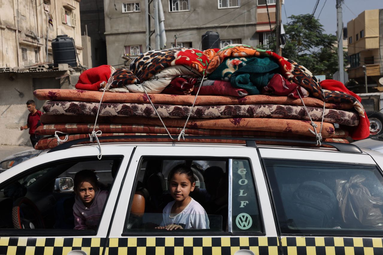 Palestinian children sit in a vehicle loaded with household items in Khan Younis refugee camp, in Khan Younis, southern Gaza, on October 28.