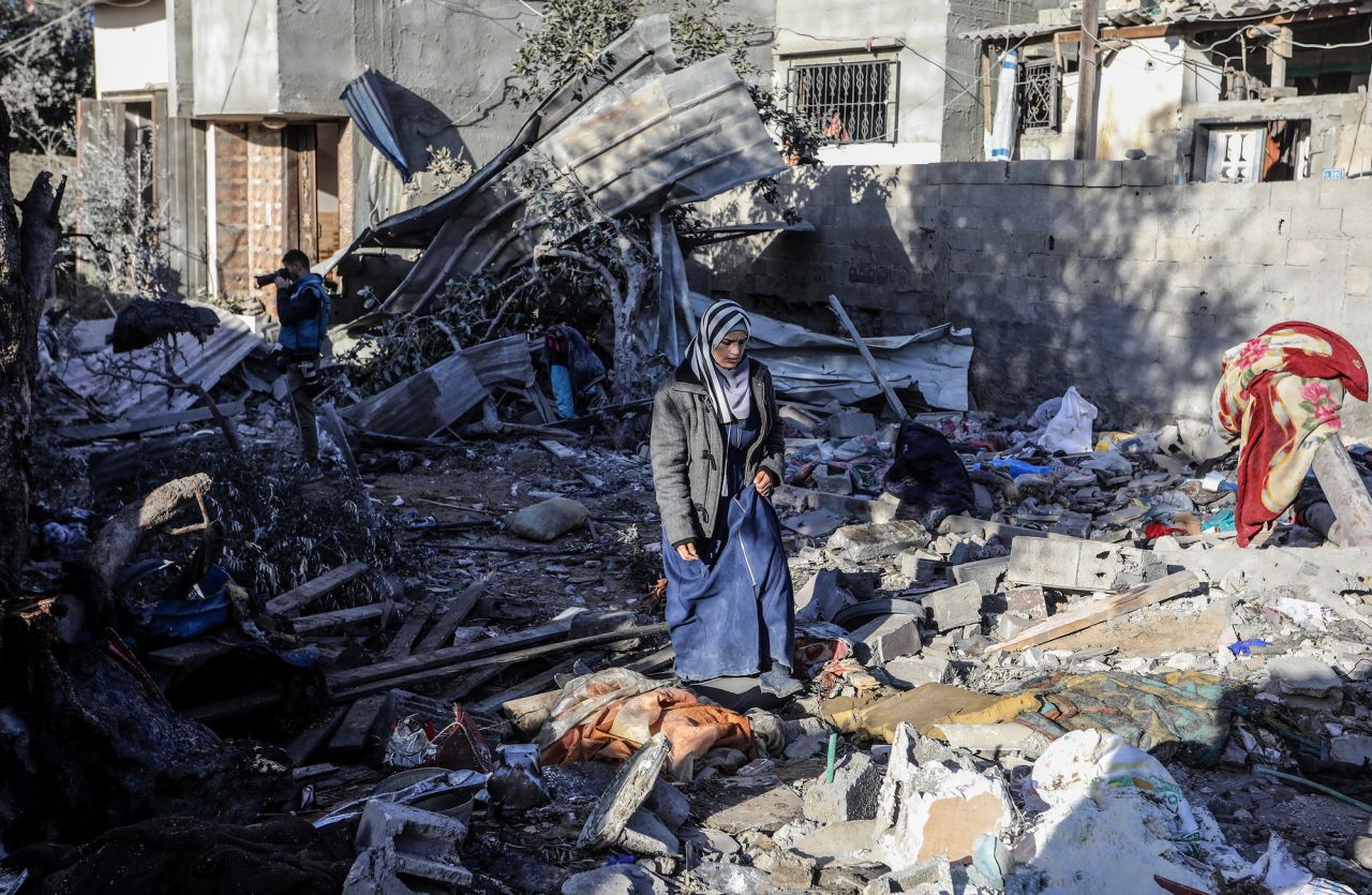 Palestinians walk among the rubble of demolished buildings after IDF attacks in Rafah, Gaza, on Thursday.