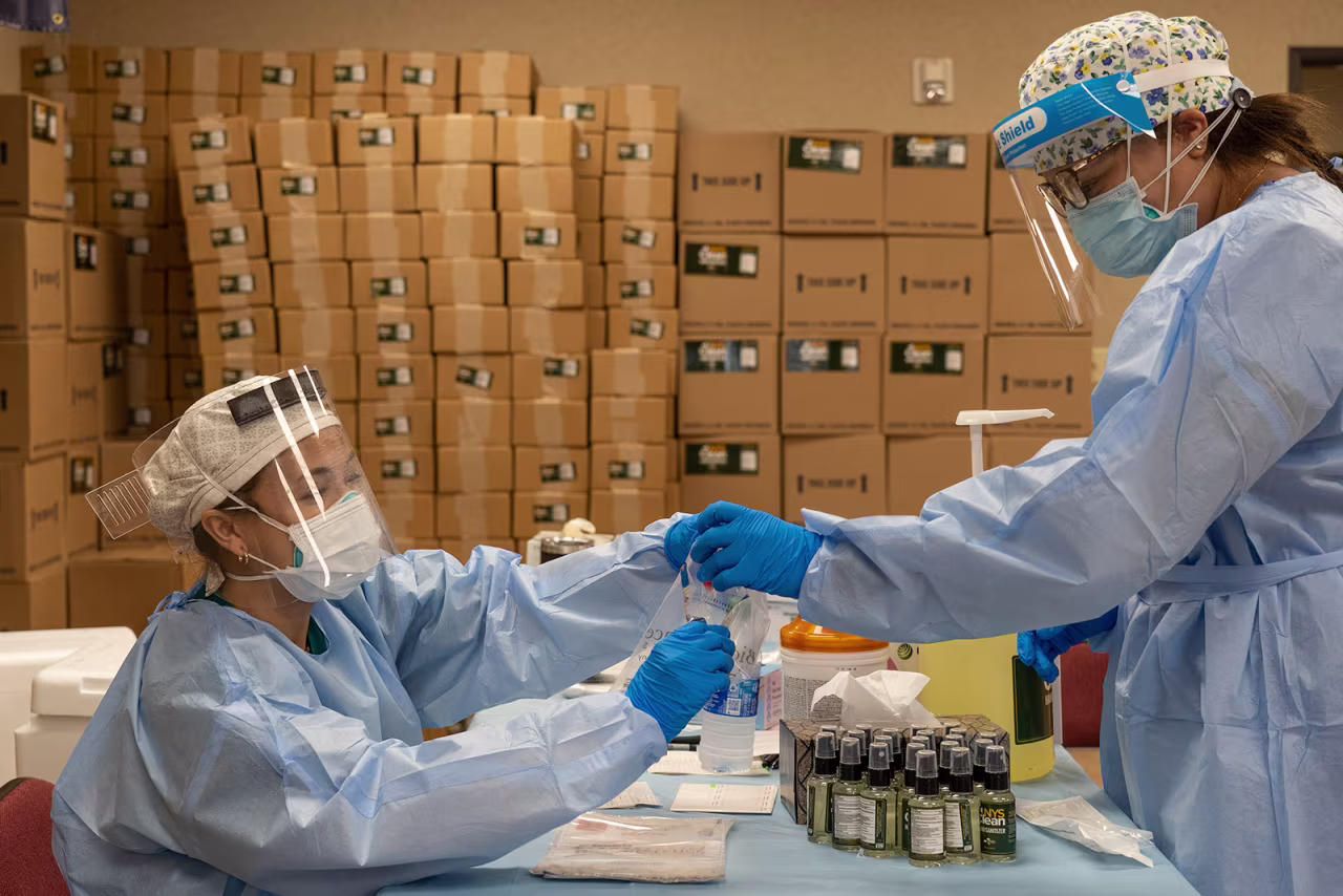 Medical workers from New York wearing personal protective equipments handle test samples at temporary testing site for Covid-19 in Higher Dimensions Church on July 17, in Houston.