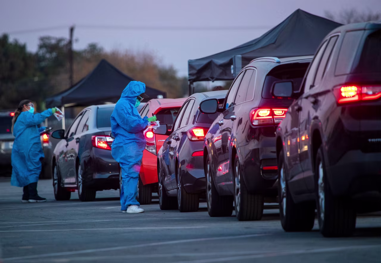 Health care workers hand out Covid-19 tests to motorists on December 9 in Long Beach, California.