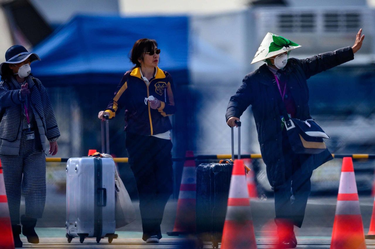 Passengers leave the Diamond Princess cruise ship in Yokohama, Japan on Thursday.