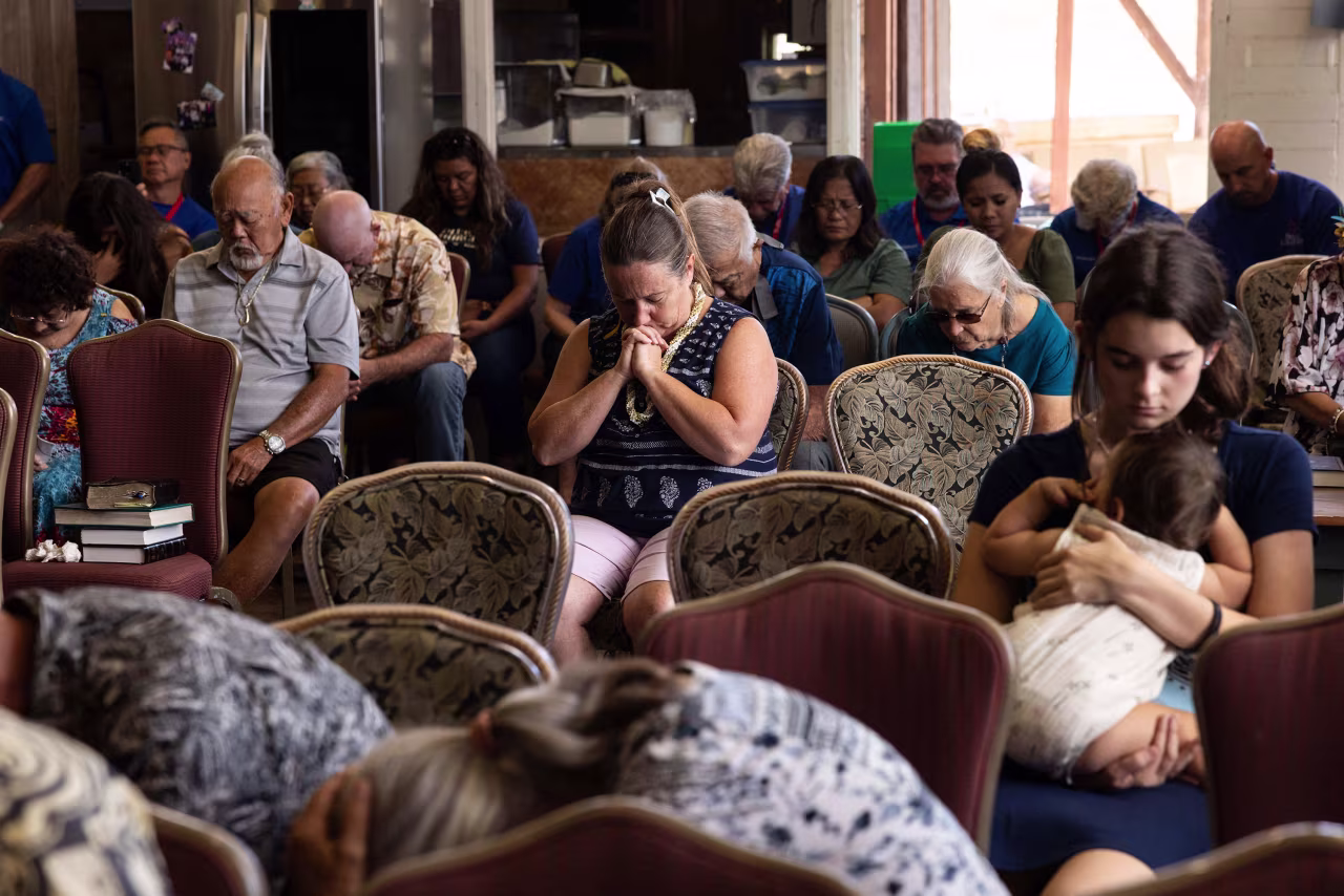 Churchgoers pray during a service held by Pastor Brown of Lahaina's Grace Baptist Church at Maui Coffee Attic in Wailuku on Sunday.