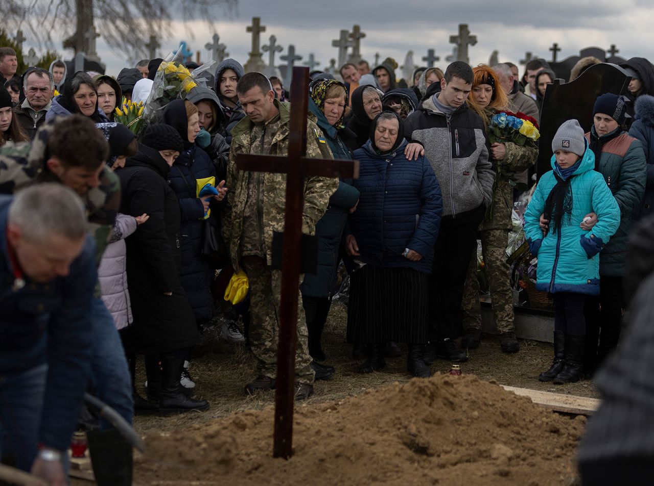 Sergey Zhelisko, center, along with family and friends, watch as his son, Ukrainian soldier Dmitry Zhelisko is buried on Sunday. 