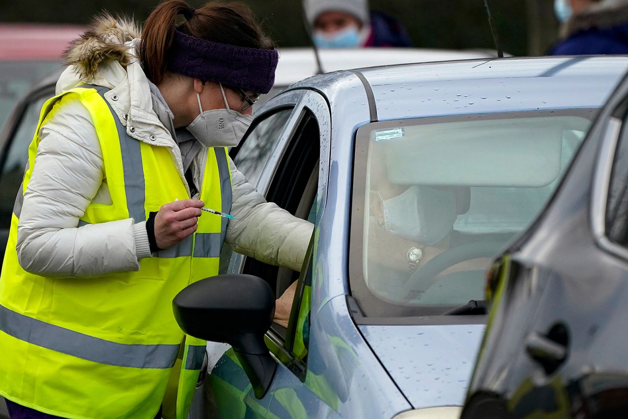 A man sits in his car as he is administered a coronavirus vaccine at a drive-thru Covid-19 vaccination centre at Hyde Leisure Centre on January 8, 2021 in Hyde, England.