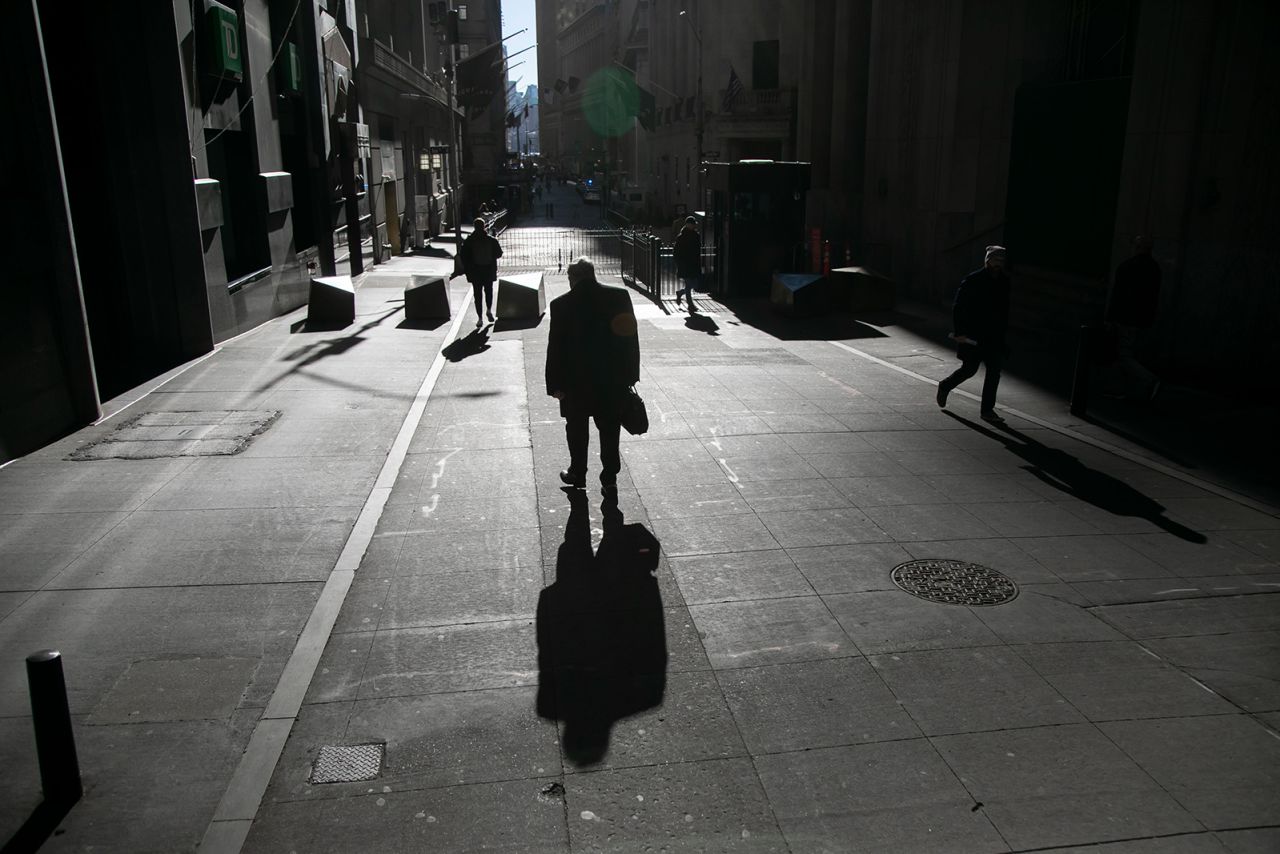 Pedestrians walk along Wall Street near the New York Stock Exchange on February 16.