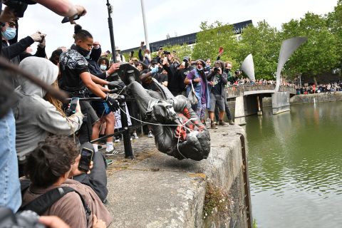 Protesters throw a statue of slave trader Edward Colston into Bristol harbor, during a Black Lives Matter protest rally, in Bristol, England, on June 7.