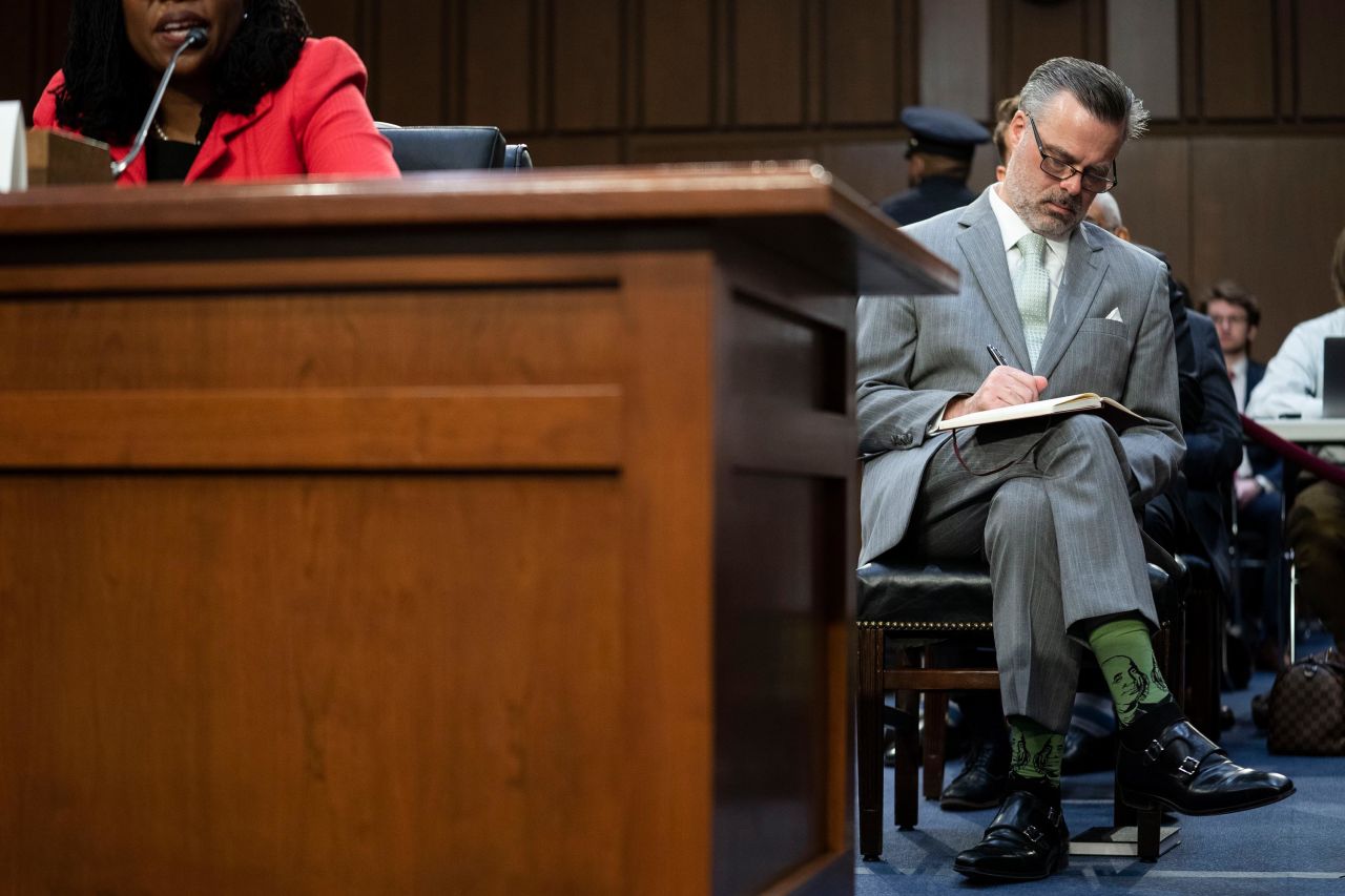 Jackson's husband, Patrick, takes notes during Tuesday's testimony. He is wearing socks with Ben Franklin on them.