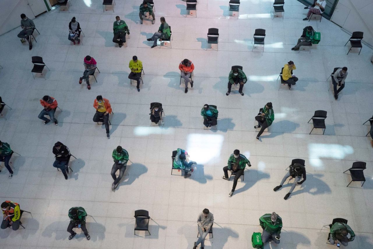 People practice social distancing as they wait for takeout food at a shopping mall in Bangkok, Thailand, on Tuesday.