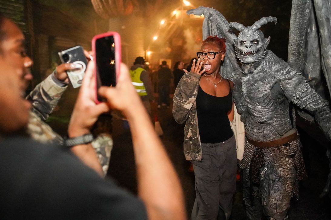 Participants pose with actors dressed as gargoyles in the Netherworld. Halloween revelers enjoy being frightened.