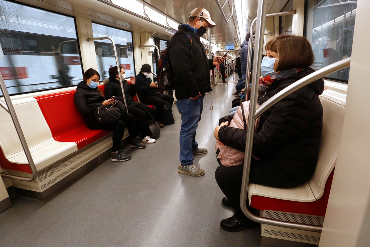 People wearing face masks ride the subway on June 16, in Santiago, Chile.