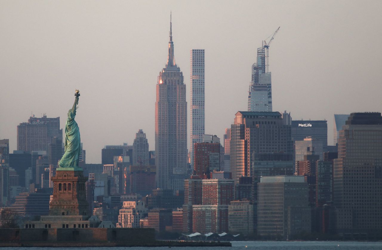 The sun sets on the Statue of Liberty and the Empire State Building in New York City on May 3. 