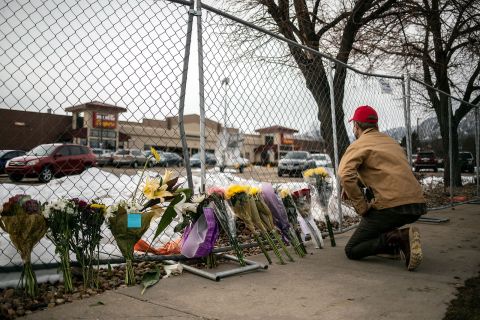A mourner leaves flowers at a makeshift memorial outside of King Soopers grocery store in Boulder, Colorado, on March 23. 