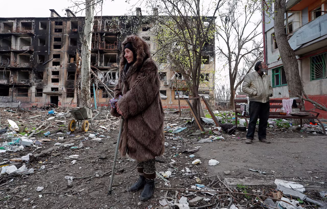 Local residents stand in a courtyard near a destroyed residential building in Mariupol, Ukraine, on Sunday, April 17. 