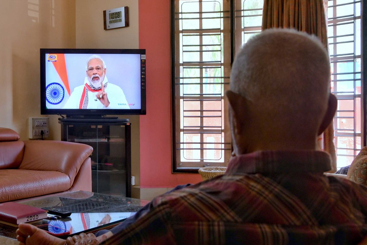 A man watches Indian Prime Minister Narendra Modi address the nation during a television broadcast in Bangalore, India, on April 14.