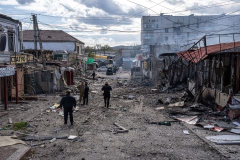 Police officers and soldiers inspect a shopping area following a Russian missile attack on October 13, in Kupiansk, Ukraine.