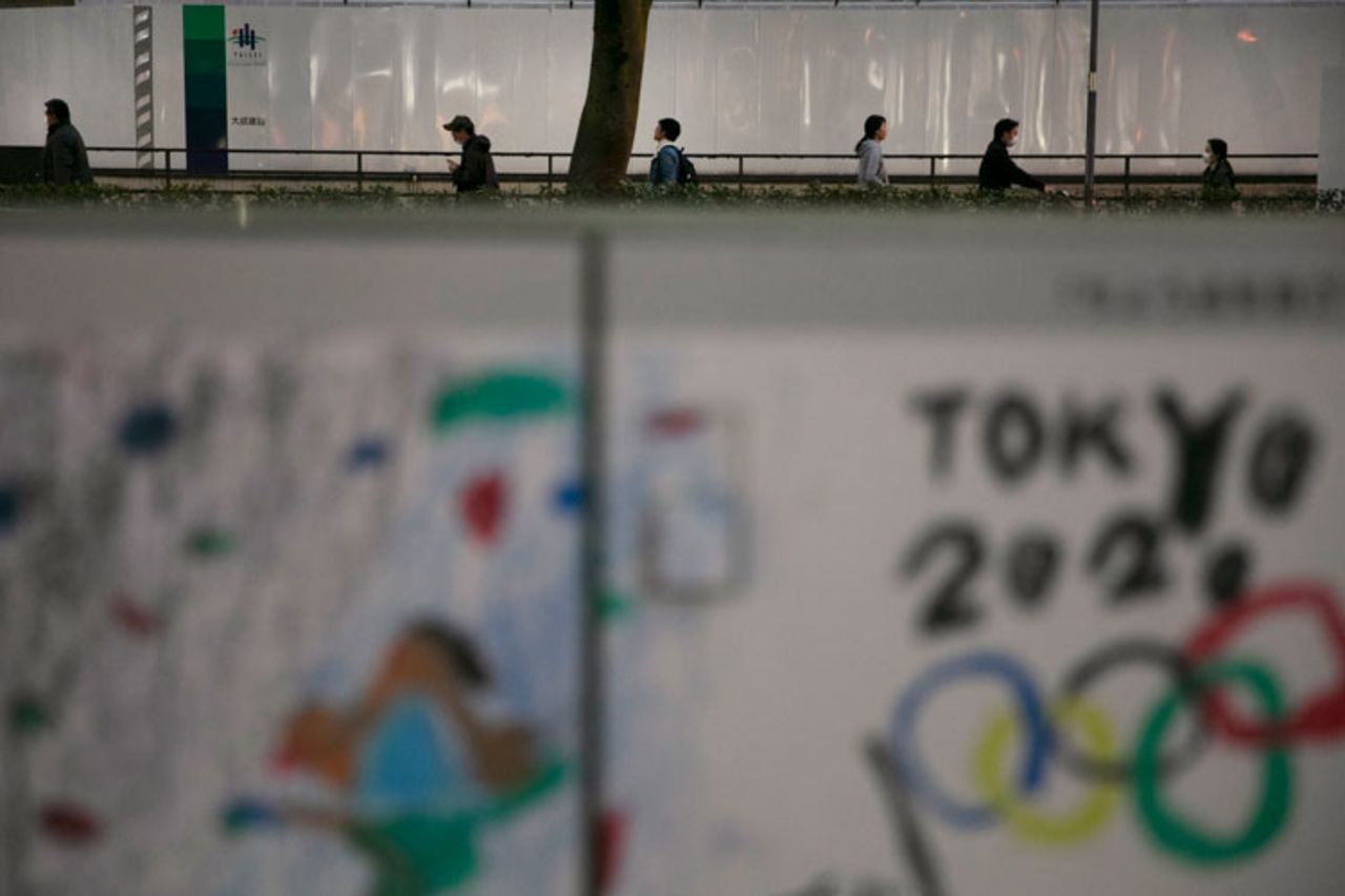 Commuters walk along a sidewalk on Tuesday, March 3, in Tokyo. 