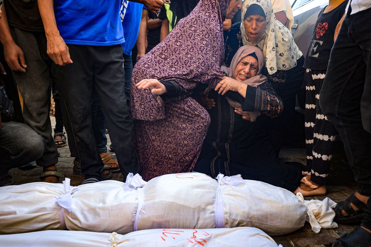 Women mourn over the shrouded bodies of three children killed in an Israeli bombing in Deir el-Balah, Gaza, on July 13. 