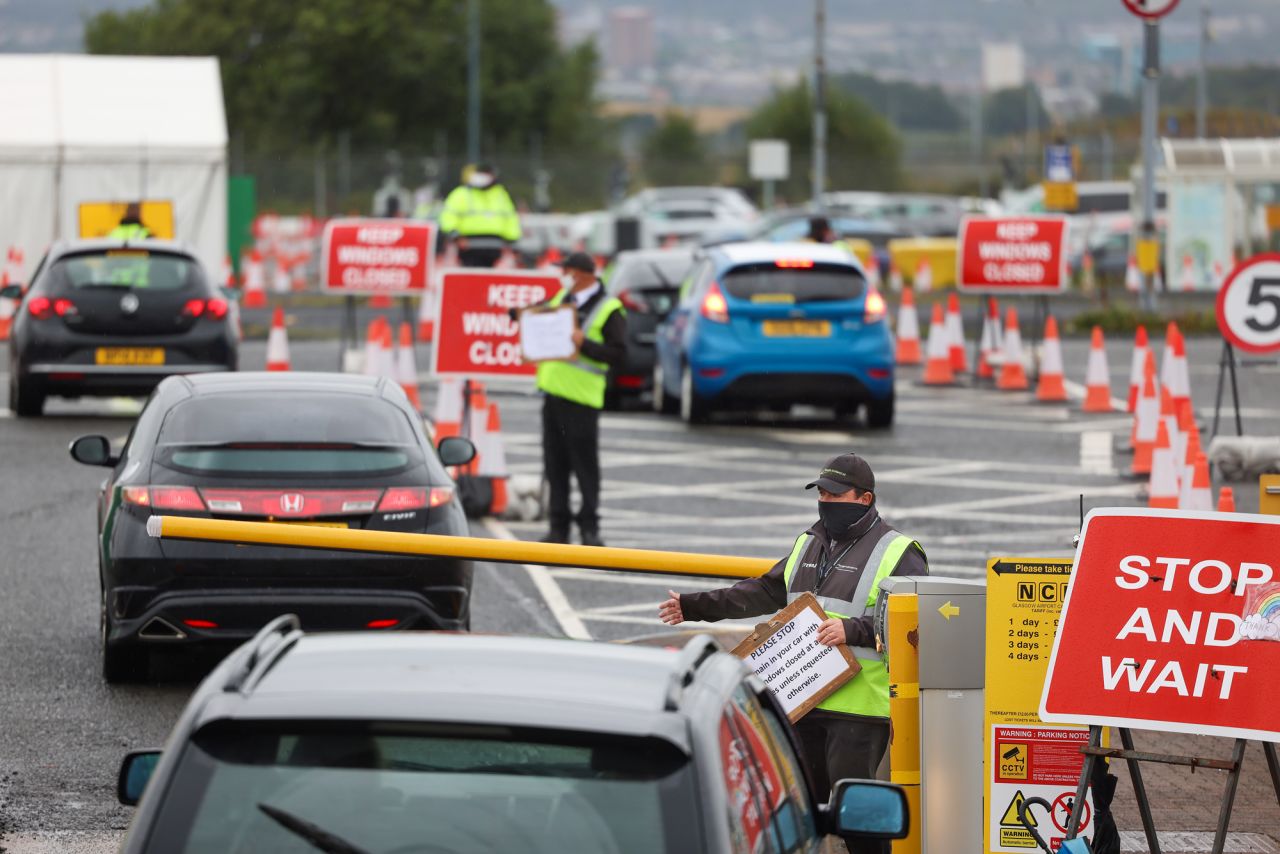 An employee directs members of the public to drive into a coronavirus testing center at Glasgow Airport on August 26 in Glasgow, Scotland.