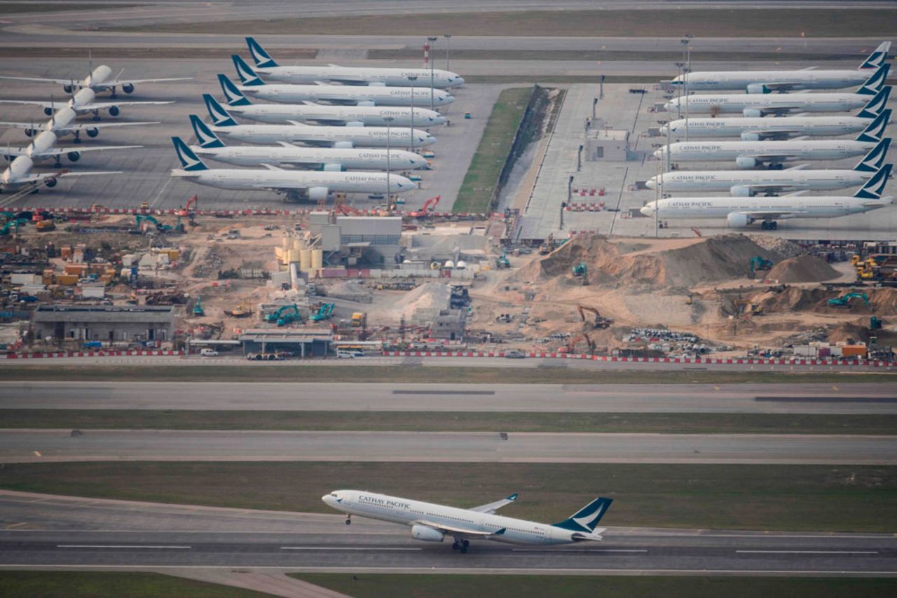 A Cathay Pacific passenger airplane takes off as other aircraft belonging to the airline are seen parked on the tarmac at Hong Kong International Airport on March 10.