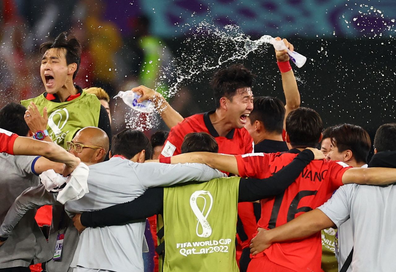 South Korea players and coaching staff celebrate after defeating Portugal.