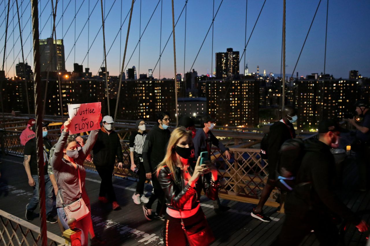 Protesters walk across the Brooklyn Bridge in New York on Sunday, May 31.