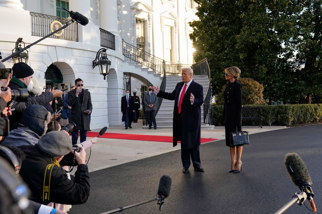 President Donald Trump and first lady Melania Trump stop to talk with the media before departing the White House on January 20.