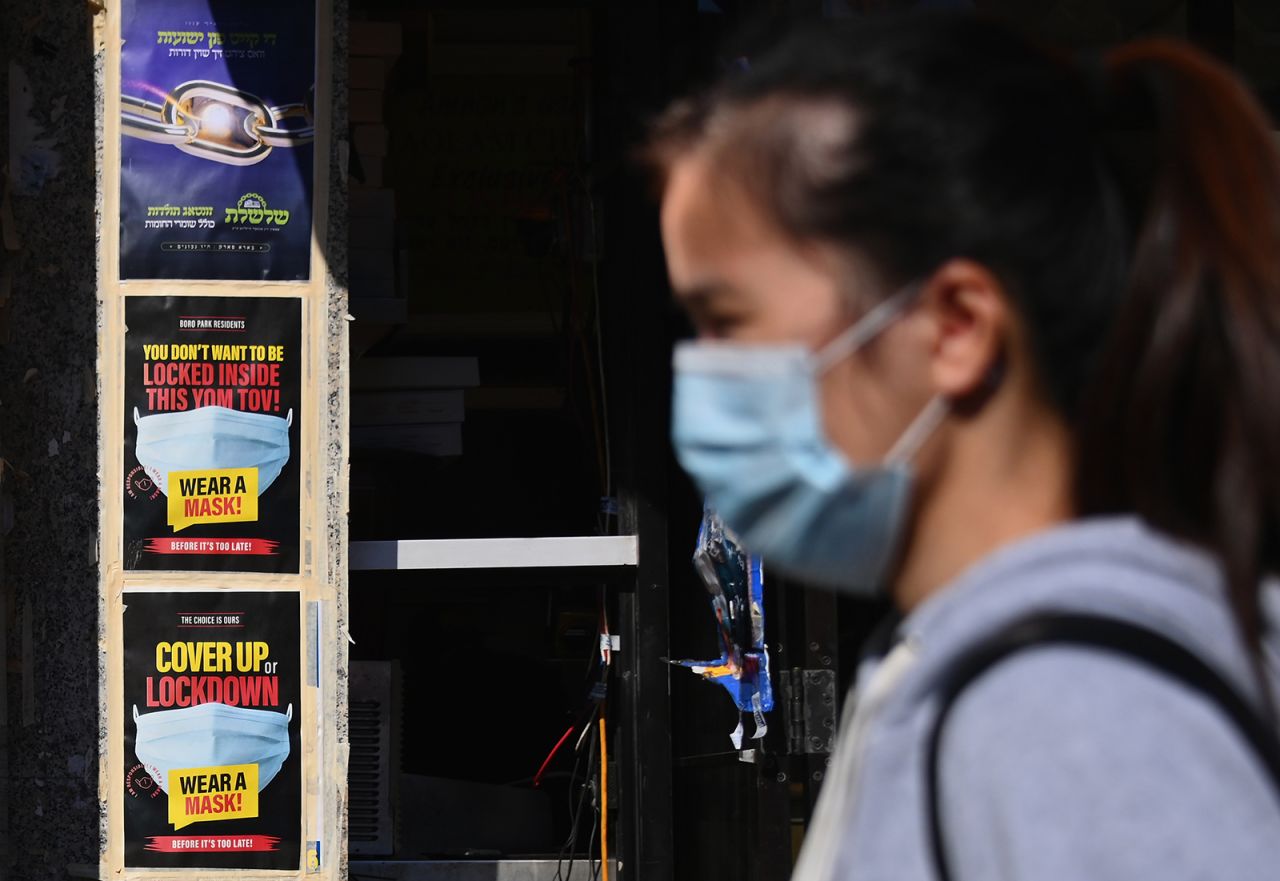 People walk past closed stores in the Borough Park section of Brooklyn, one of the five boroughs of New York City, on October 9.