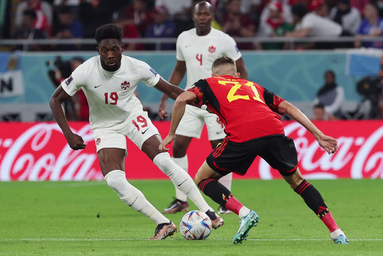 Canada's Alphonso Davies fights for the ball with Belgium's Timothy Castagne on November 23.
