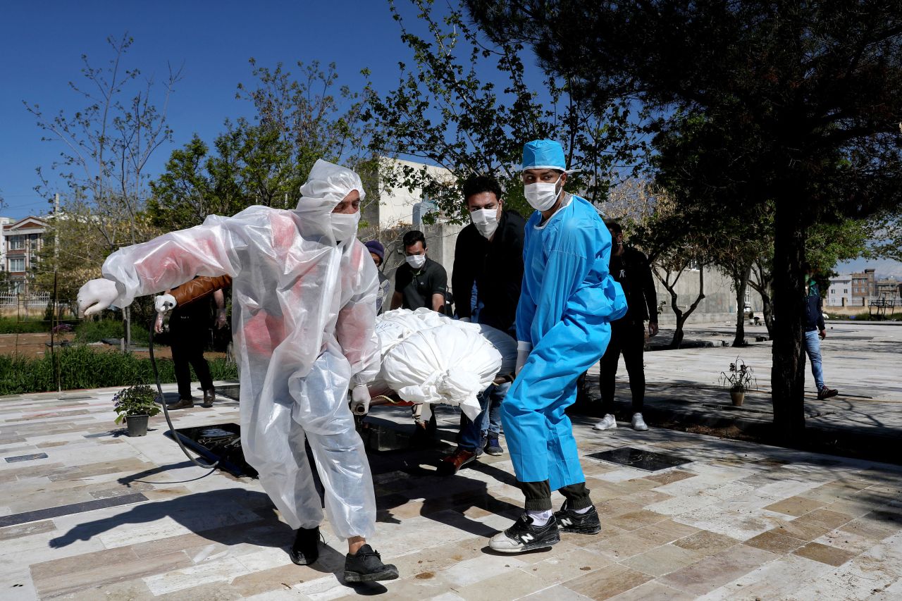 People wear protective clothing while carrying the body of a victim who died from coronavirus at a cemetery just outside Tehran, Iran, on March 30.