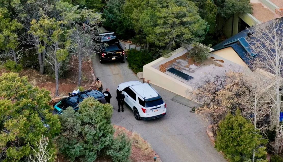Agentes de la ley conversan fuera de la casa del actor Gene Hackman el jueves en Santa Fe, Nuevo México.