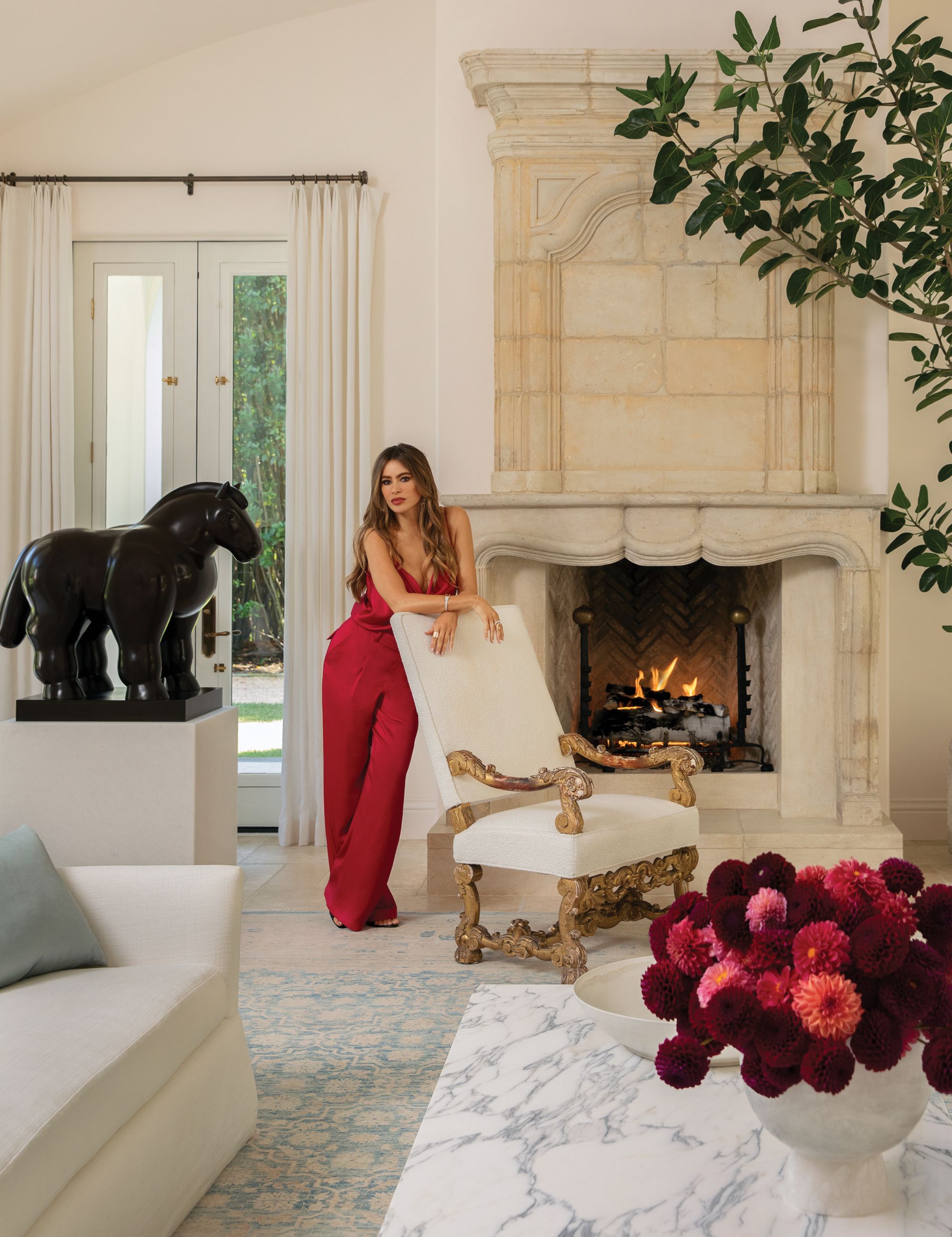 An 18th-century limestone fireplace lights up the living room in Sofia Vergara's home.