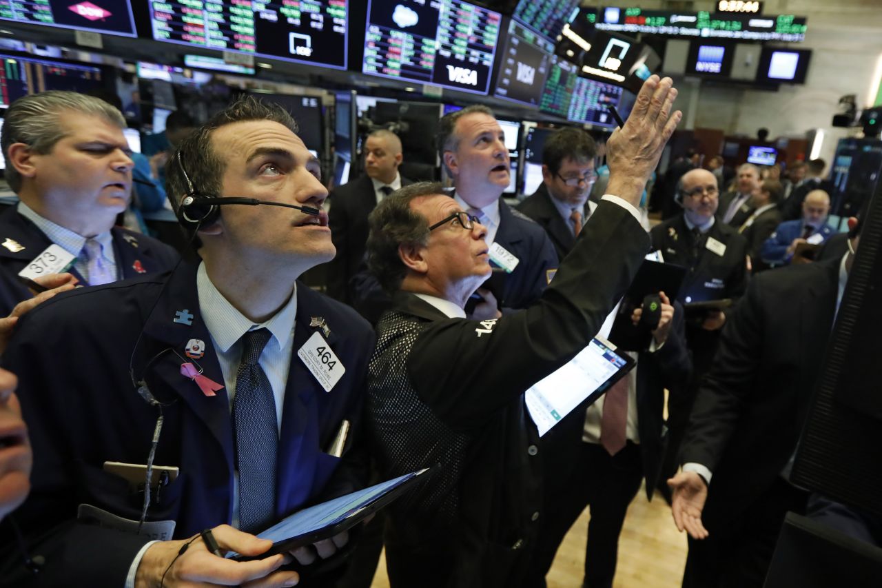 Traders gather at a post on the floor of the New York Stock Exchange, on Wednesday, March 4.