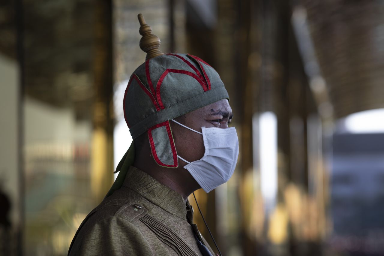 A Cambodian hotel guard wearing a mask stands outside a hotel in Phnom Penh, Cambodia.