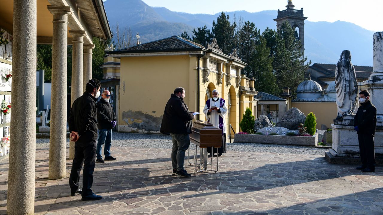 A priest conducts a funeral service without relatives inside the cemetery of Zogno, Italy, on March 21.