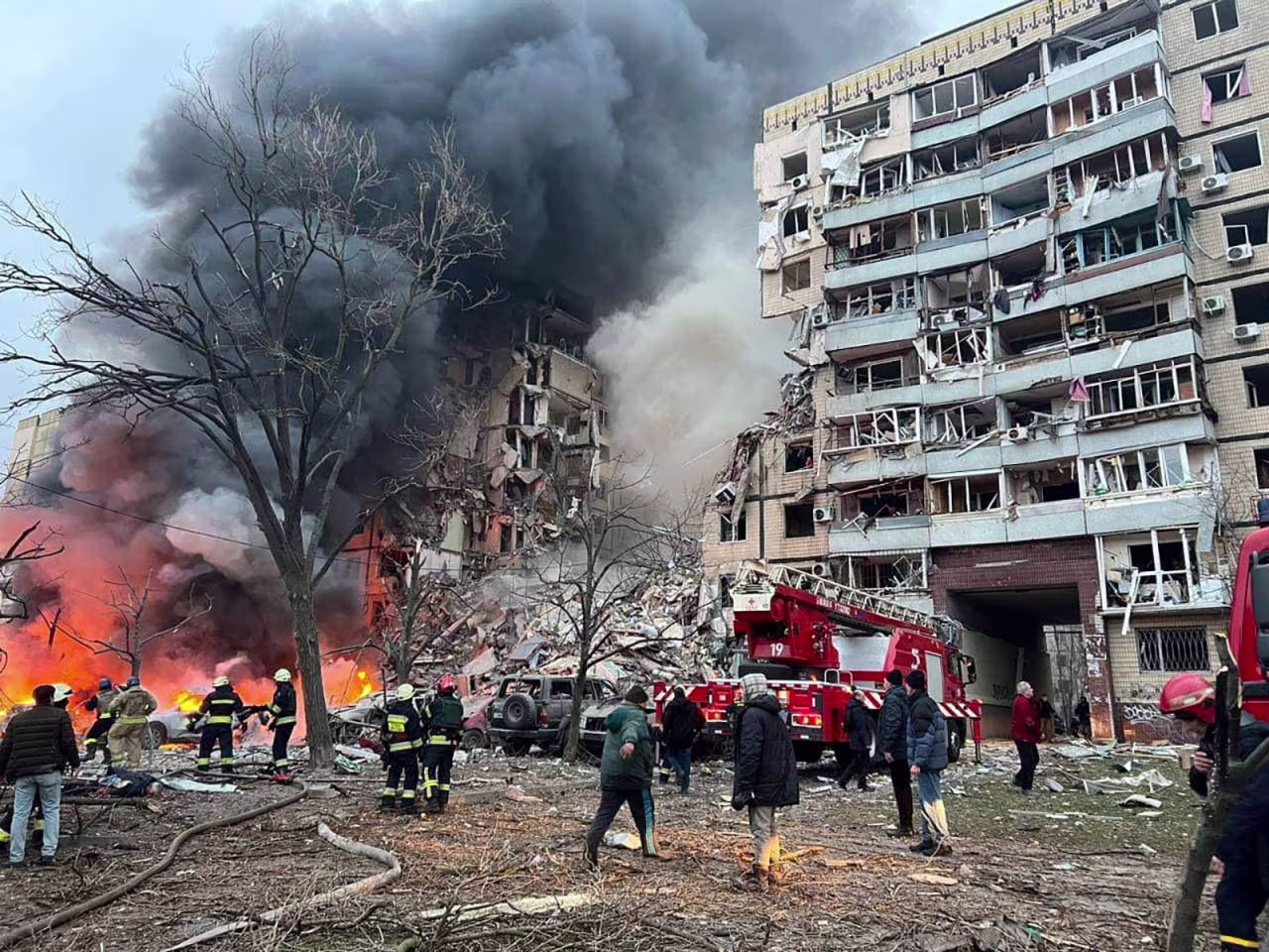 Rescuers and local residents are seen at a site of an apartment building heavily damaged by a Russian missile strike in Dnipro on Saturday.