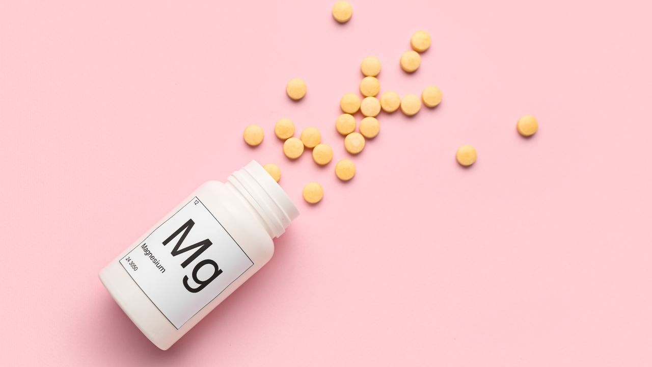 Bottle of magnesium pills on pink background