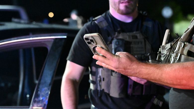 Officers look through a phone after stopping a suspected smuggler.