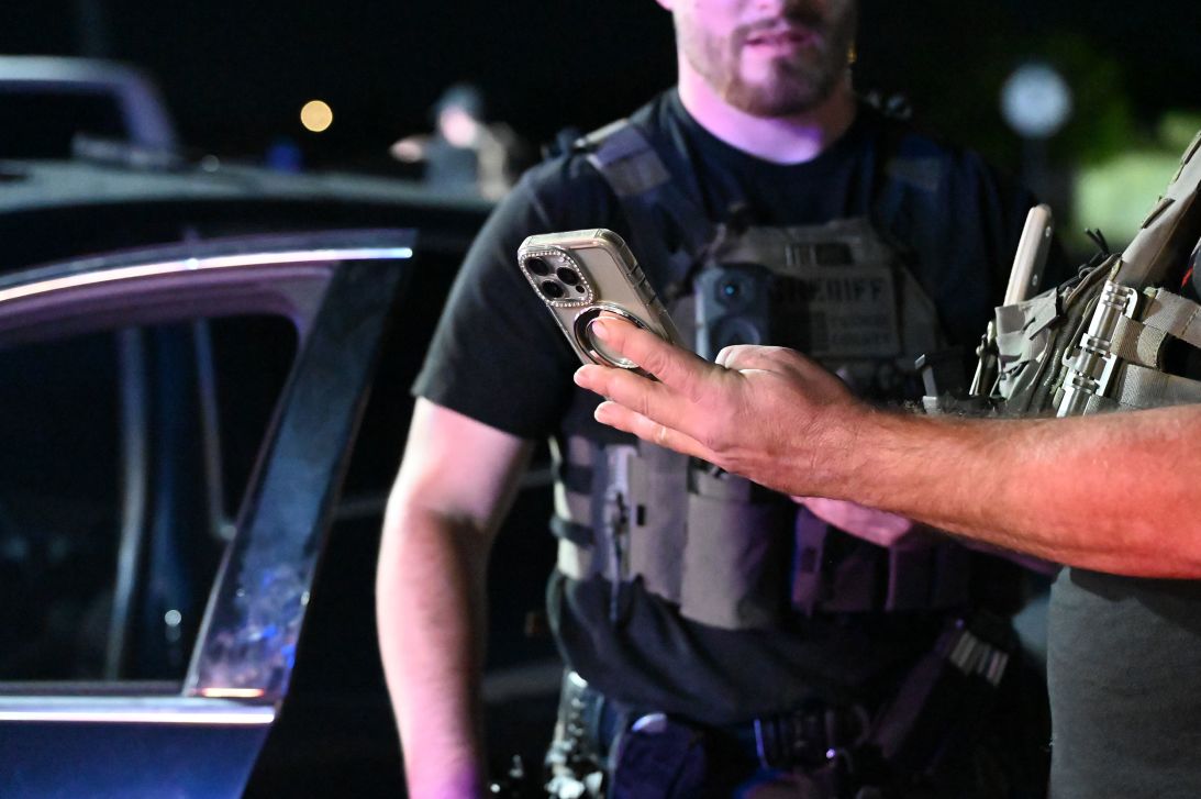 Officers look through a phone after stopping a suspected smuggler.