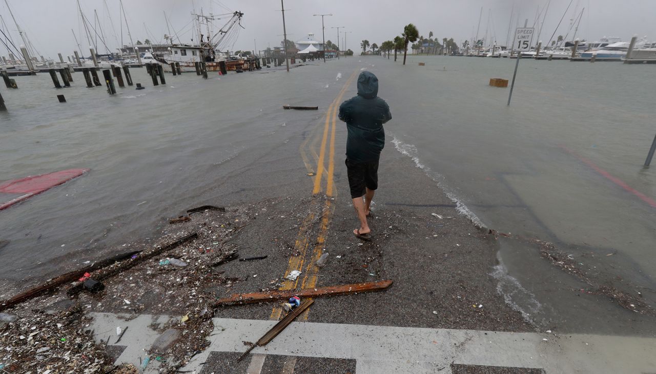 A person walks up a road beginning to flood as Hurricane Hanna makes landfall on Saturday in Corpus Christi, Texas.