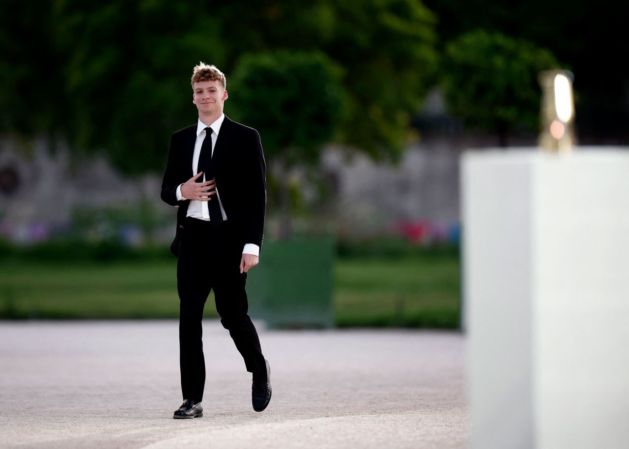 French swimmer Léon Marchand arrives to receive the Olympic flame. 