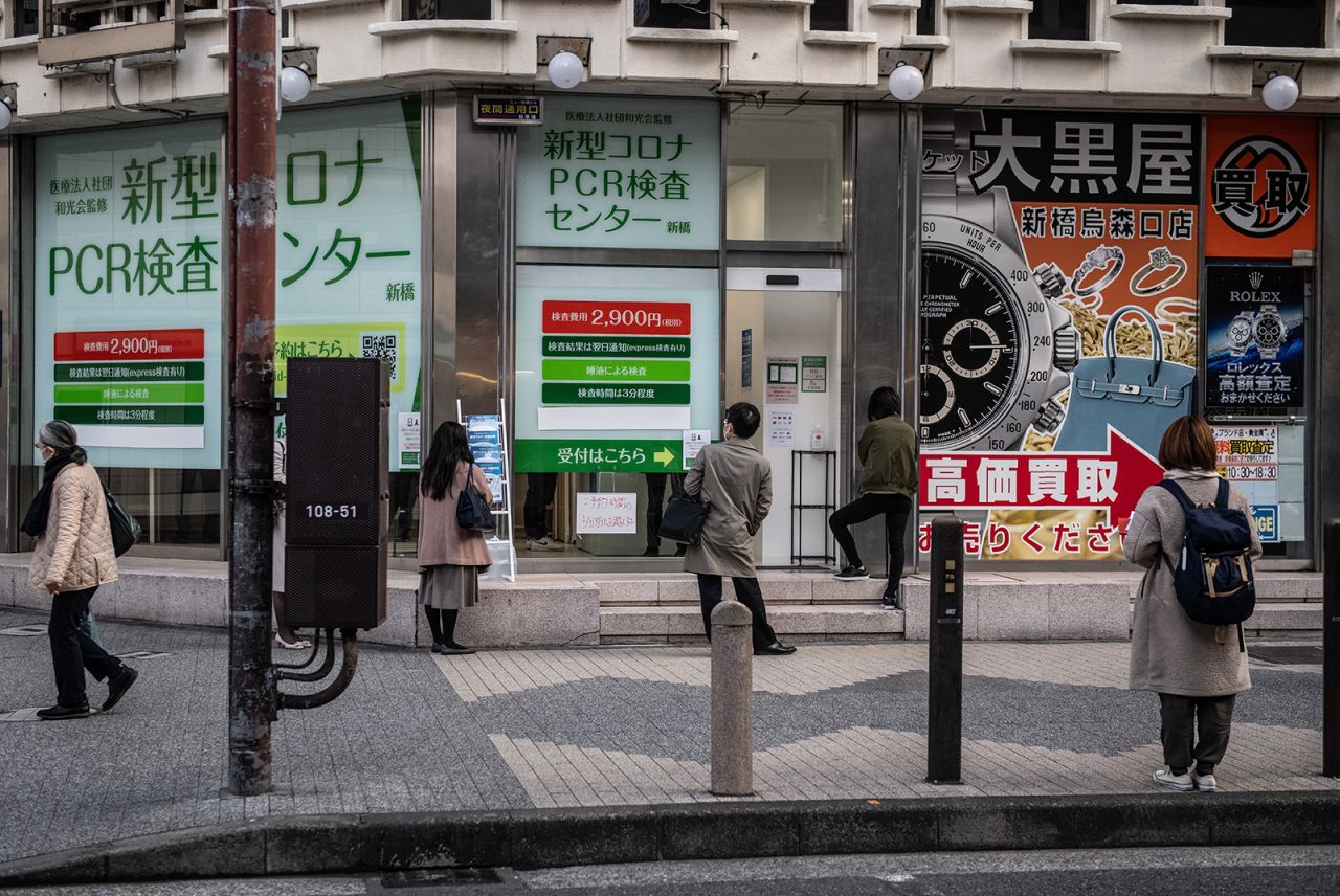 People socially distance as they queue to access a coronavirus PCR testing centre in Tokyo, on December 11.