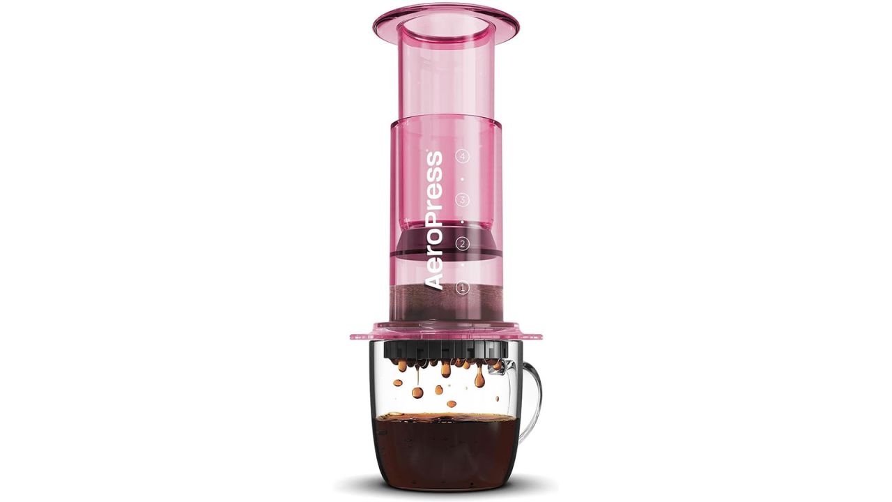 Pink AeroPress Coffee Maker over clear cup.