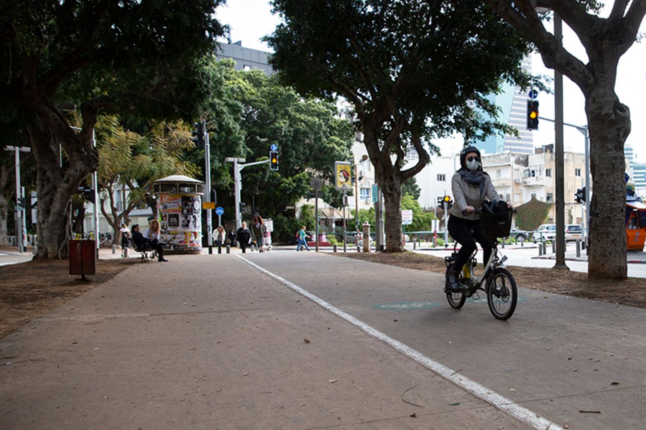 A woman wears a mask as she rides a bicycle in Tel Aviv, Israel, Tuesday, March 17. 