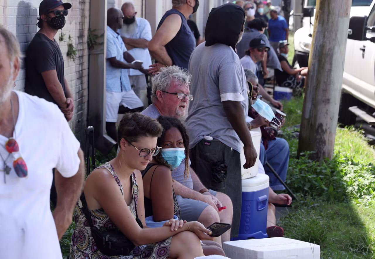 People waiting in extreme heat to buy ice at Duplantier Ice Service in New Orleans, Louisiana on September 1, 2021, as power remained out in most of the city after Hurricane Ida ripped through the state. 