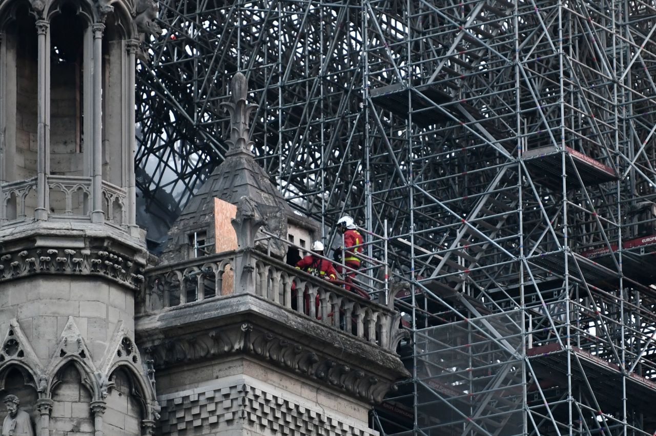 Firefighters continue to work to extinguish the fire at Notre Dame Cathedral. The fire is under control but there are "still outbreaks," a Ministry of the Interior spokesman said Tuesday morning. 