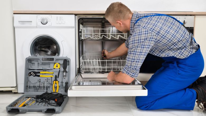 Service technician fixing a dishwasher.