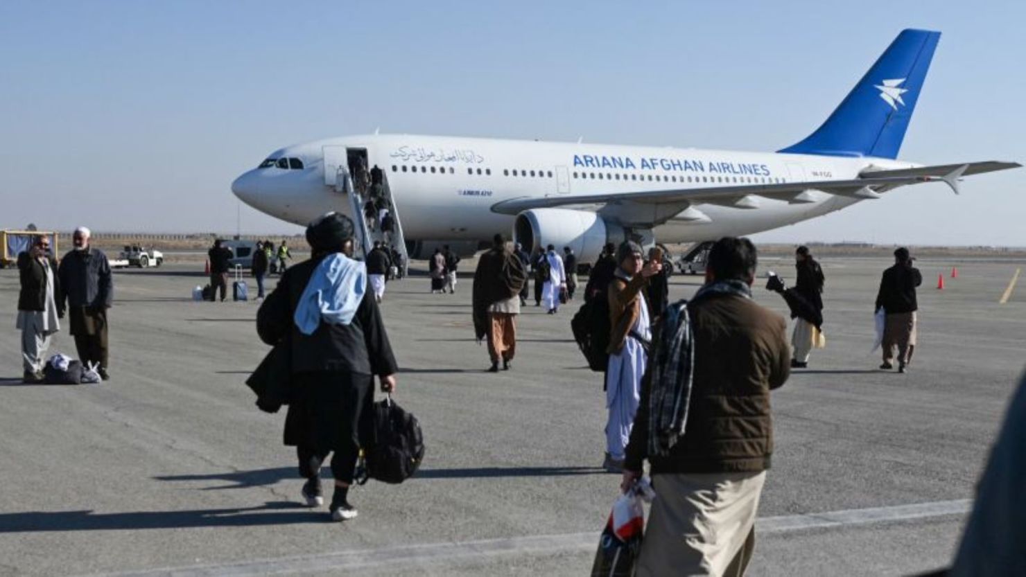 Los pasajeros caminan para abordar un avión comercial de Ariana Afghan Airlines en el Aeropuerto Internacional Khwaja Abdullah Ansari, el 23 de diciembre de 2024.