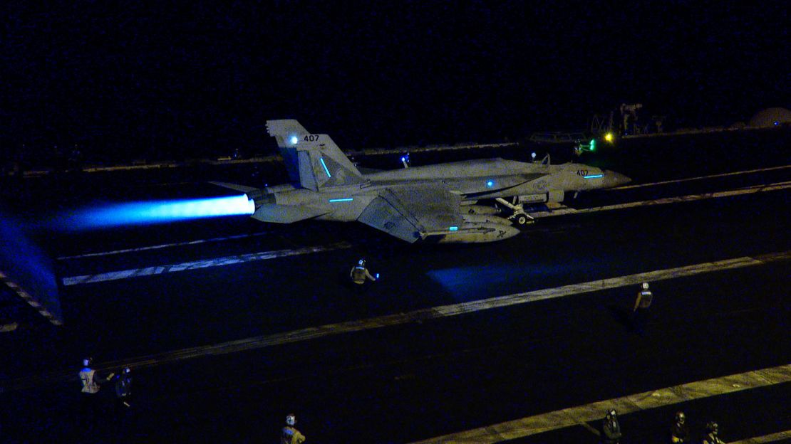 An F/A-18 with afterburner prepares to launch from the deck of the USS Dwight D. Eisenhower aircraft carrier in the Red Sea.