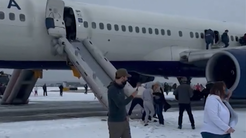 shows over 200 Delta airlines passengers evacuating onto snowy tarmac in Atlanta