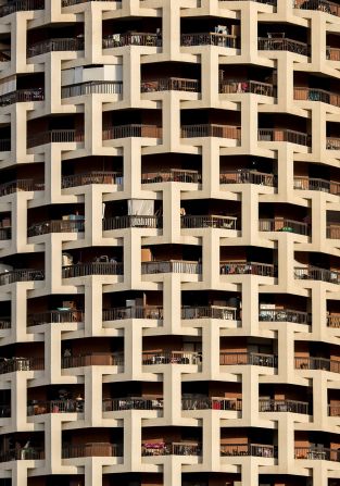 Al-Ibrahimi Building, Abu Dhabi: AlMoosawi describes the the 16-story cylindrical Al-Ibrahimi Building as "eye-poppingly attractive." Built in the 1980s it features "balconies inside interlocking cubes that look like white ribbon."
